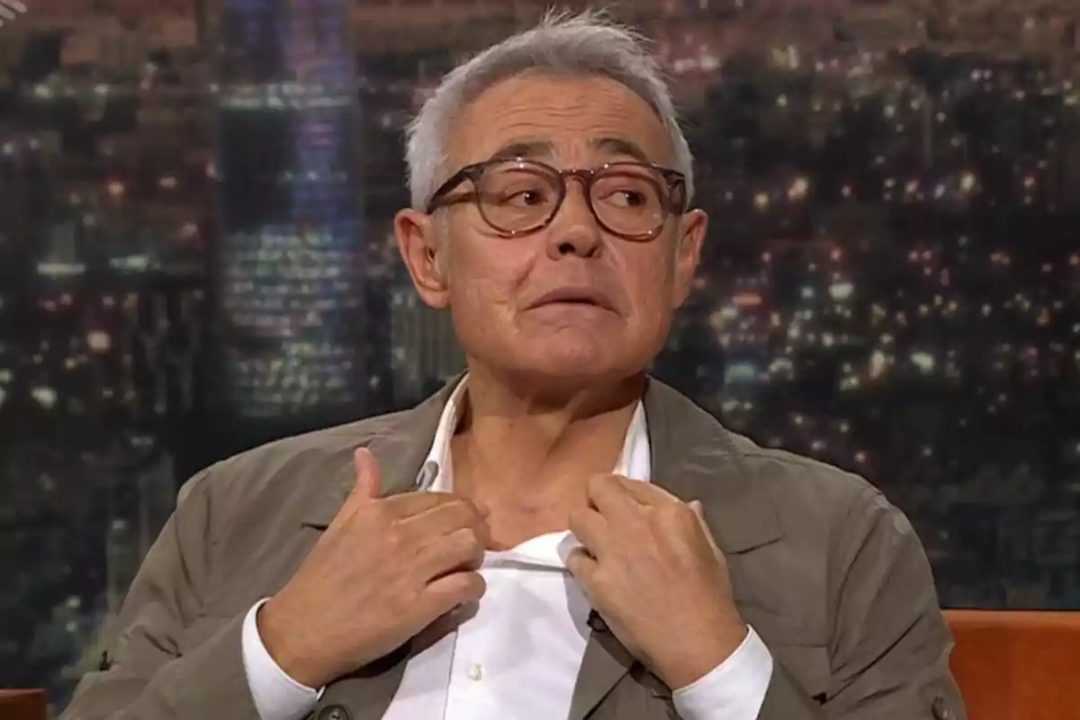 Jordi González de cabello canoso y gafas mostrando una cicatriz en el cuello durante una entrevista en Col·lapse con fondo de ciudad desenfocado Jordi González de cabello canoso y gafas mostrando una cicatriz en el cuello durante una entrevista en Col·lapse con fondo de ciudad desenfocado