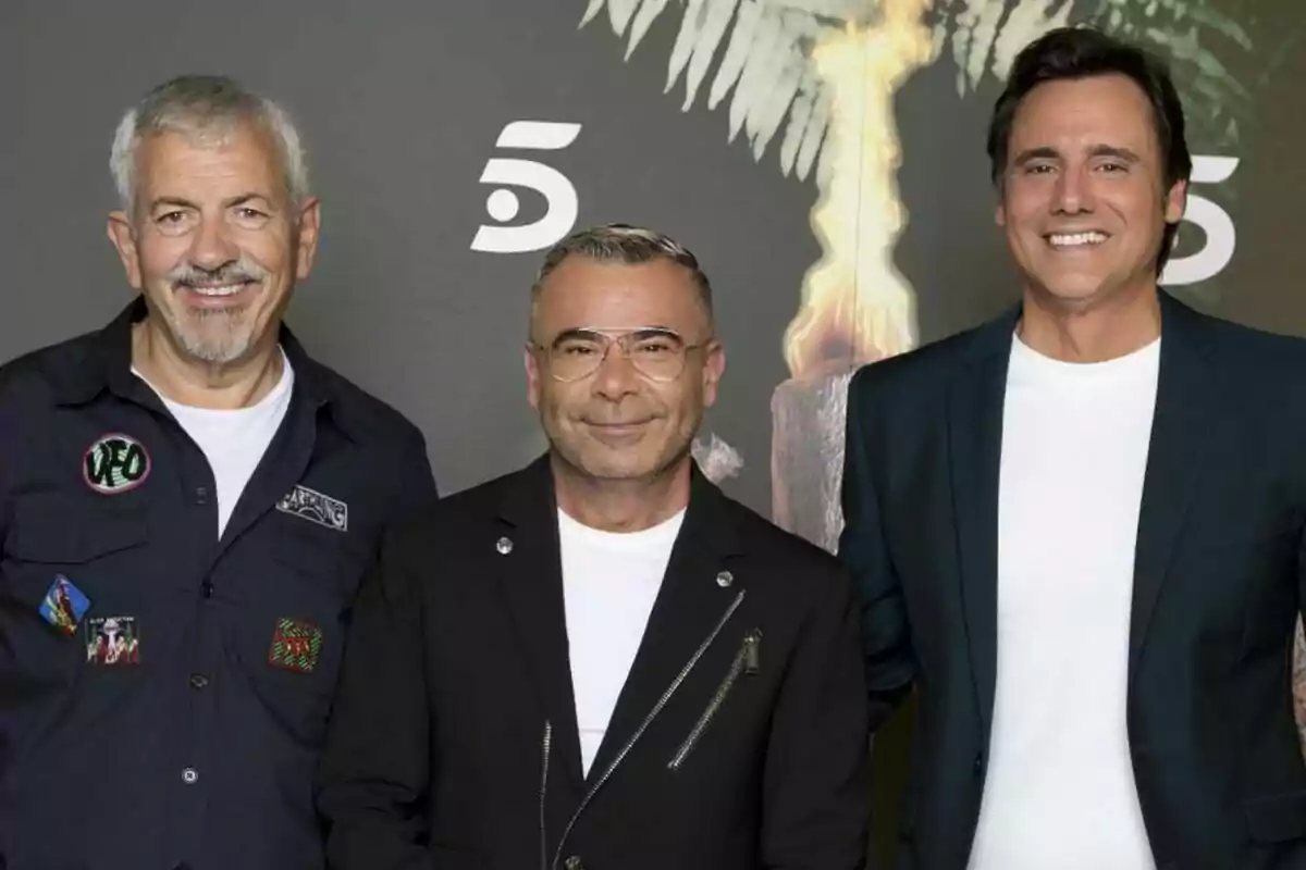 Carlos Sobera, Jorge Javier Vázquez y Ion Aramendi sonrientes posan juntos frente a un fondo oscuro con el logo de un canal de televisión y una antorcha de Supervivientes encendida Carlos Sobera, Jorge Javier Vázquez y Ion Aramendi sonrientes posan juntos frente a un fondo oscuro con el logo de un canal de televisión y una antorcha de Supervivientes encendida