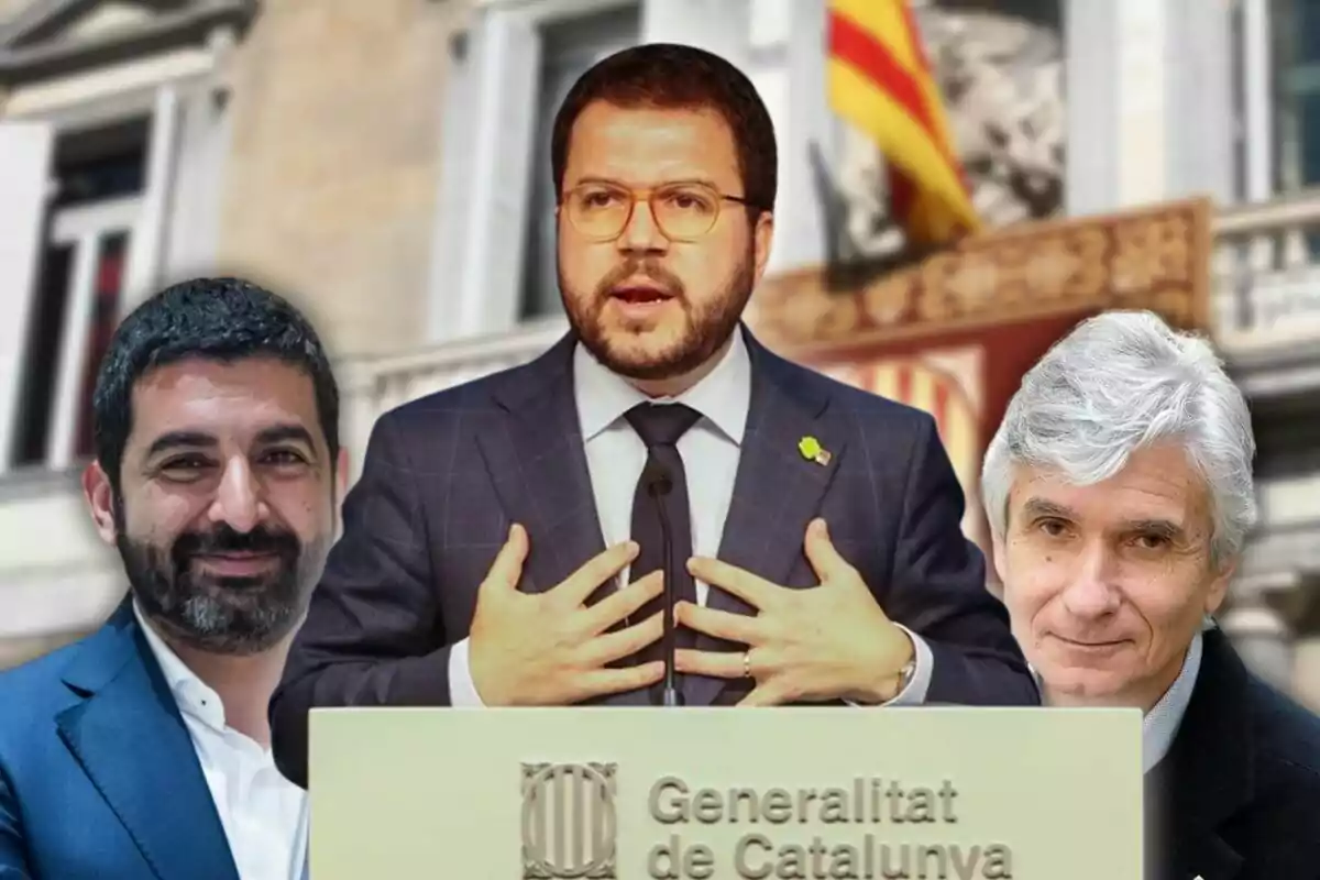 Un hombre en traje habla en un podio con el emblema de la Generalitat de Catalunya mientras dos personas están a su lado y una bandera catalana se ve al fondo.