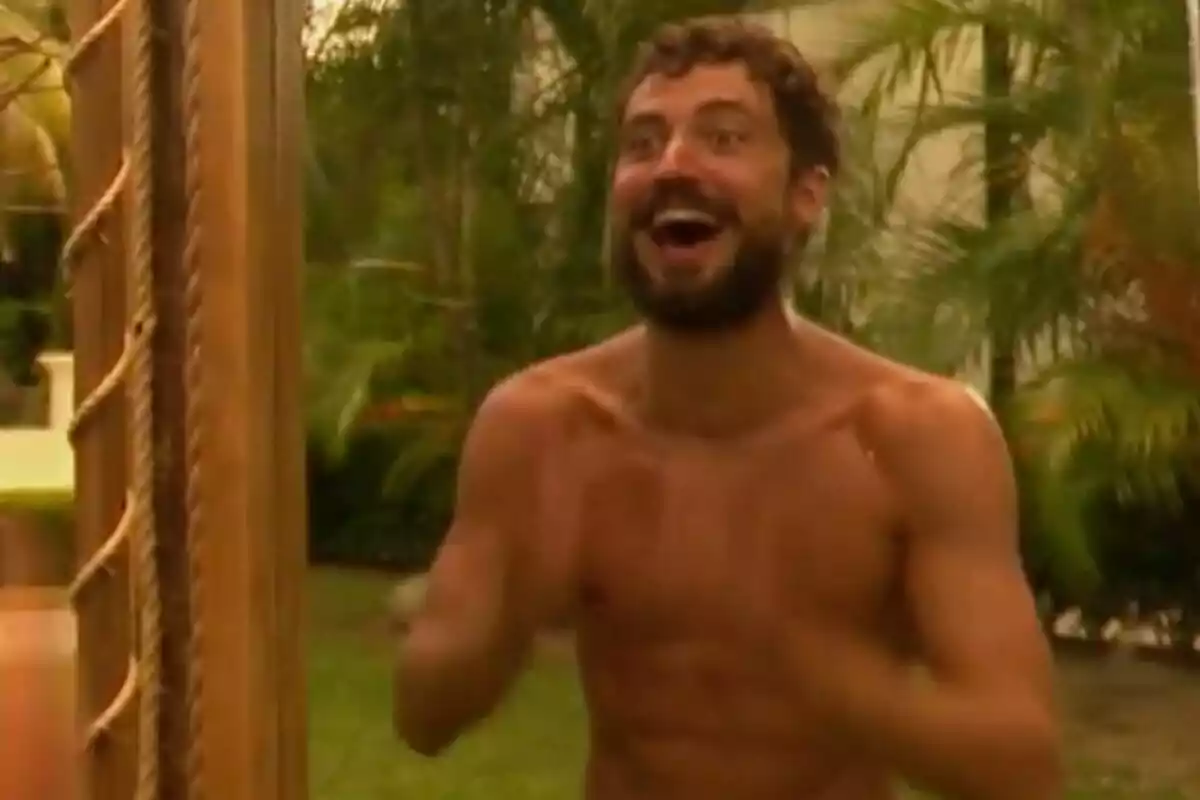 Joshua Velázquez sin camisa con expresión de alegría en un entorno al aire libre con plantas de fondo en 'Supervivientes'.