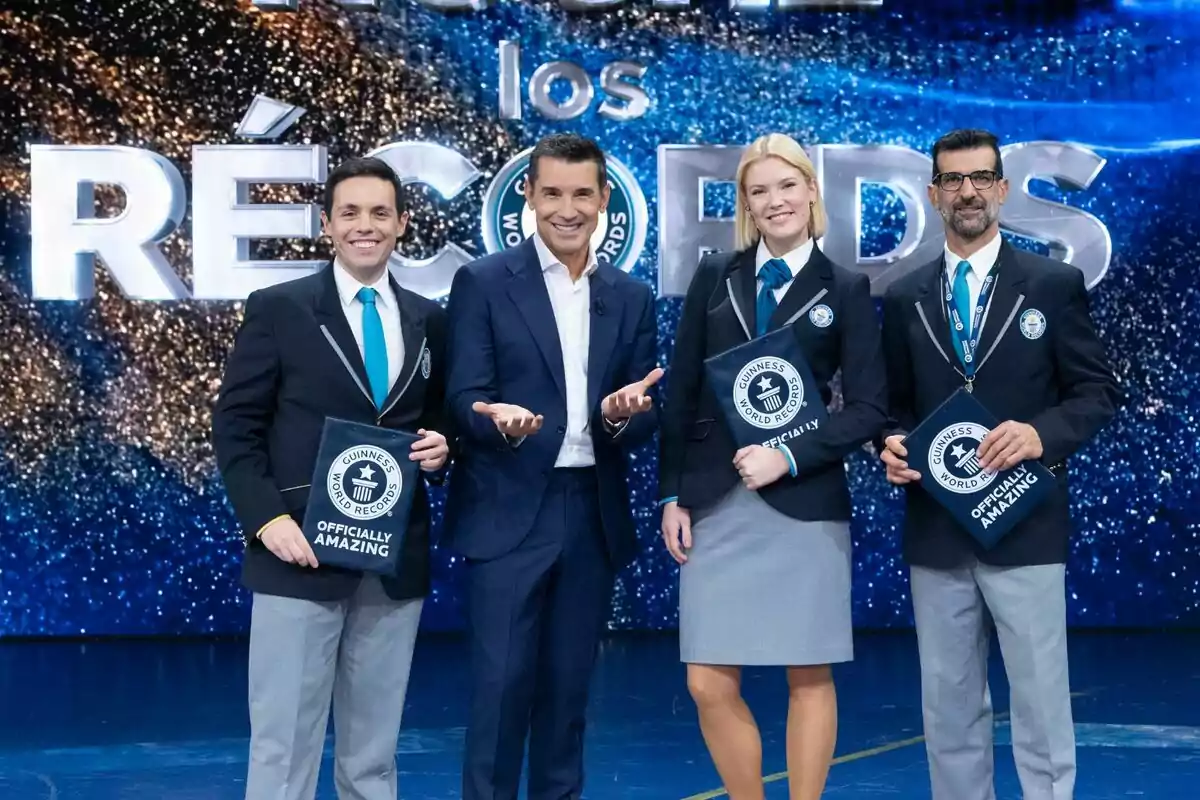 Los jueces y Jesús Vázquez posando en un escenario con el logotipo de Guinness World Records en el fondo, todos vestidos con trajes formales y sonriendo a la cámara. Los jueces y Jesús Vázquez posando en un escenario con el logotipo de Guinness World Records en el fondo, todos vestidos con trajes formales y sonriendo a la cámara.