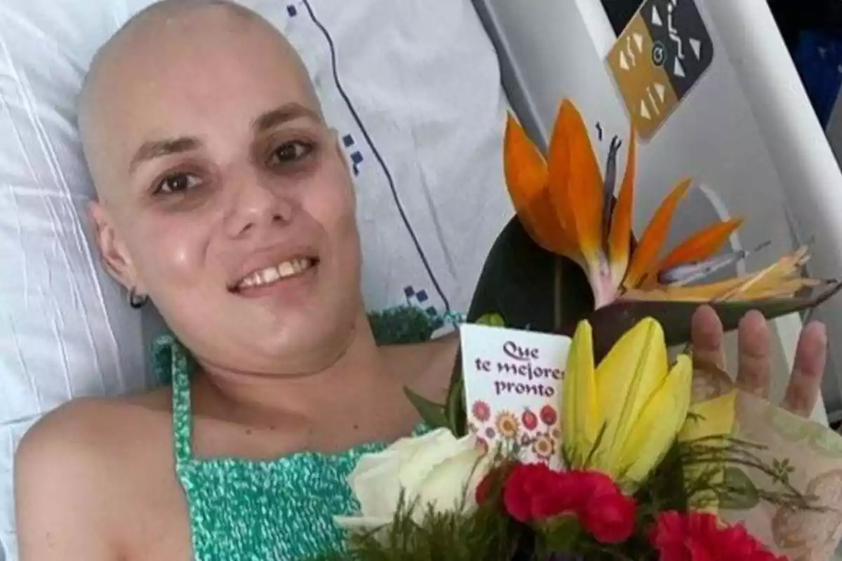 Juliet Osorio en una cama de hospital con un ramo de flores