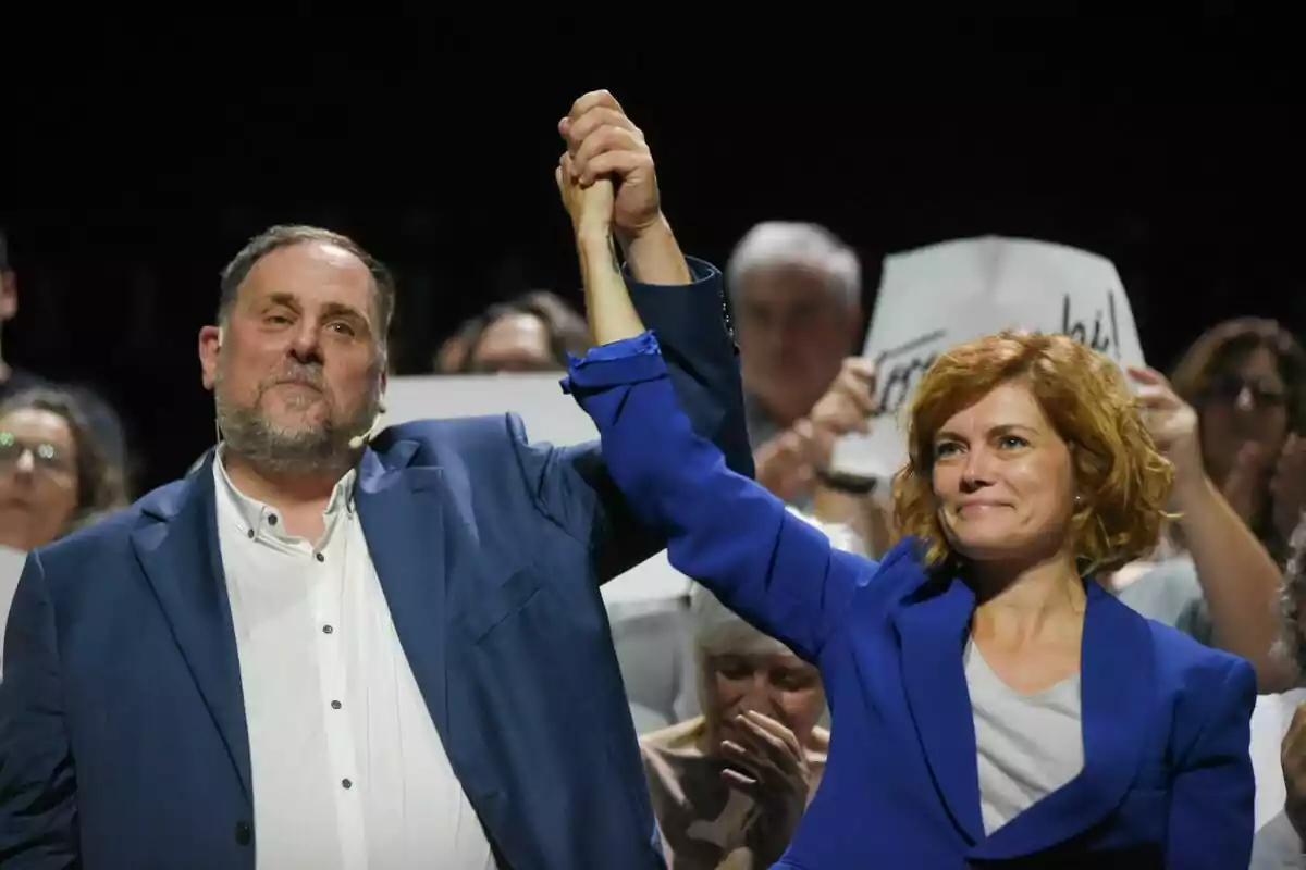 Oriol Junqueras y Elisenda Alamany, dándose la mano en un mitin político con gente de fondo