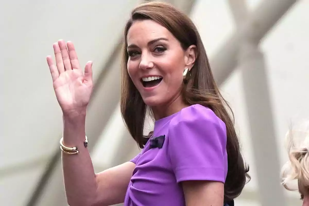 Kate Middleton con vestido morado saludando y sonriendo.