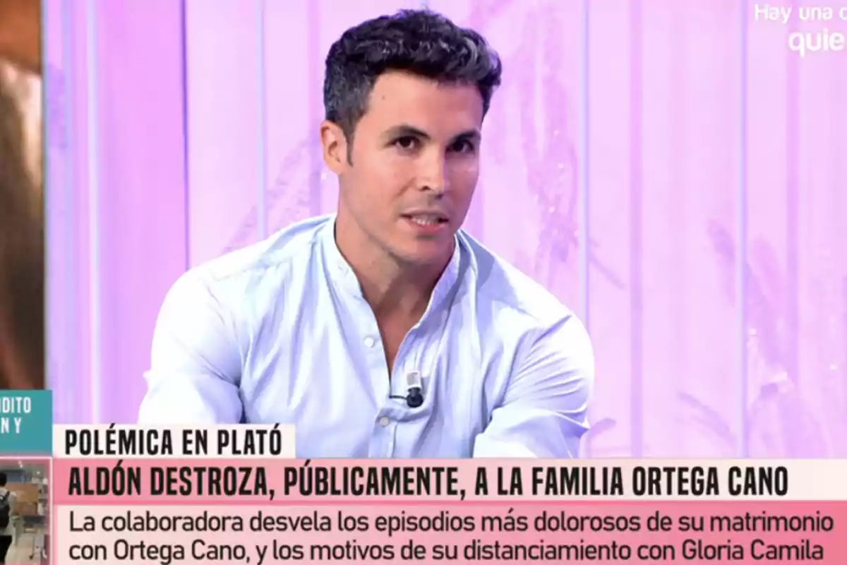 Kiko Jiménez con camisa clara está sentado en un plató de televisión con un fondo rosado y texto en la parte inferior que menciona una polémica relacionada con la familia Ortega Cano. Kiko Jiménez con camisa clara está sentado en un plató de televisión con un fondo rosado y texto en la parte inferior que menciona una polémica relacionada con la familia Ortega Cano.
