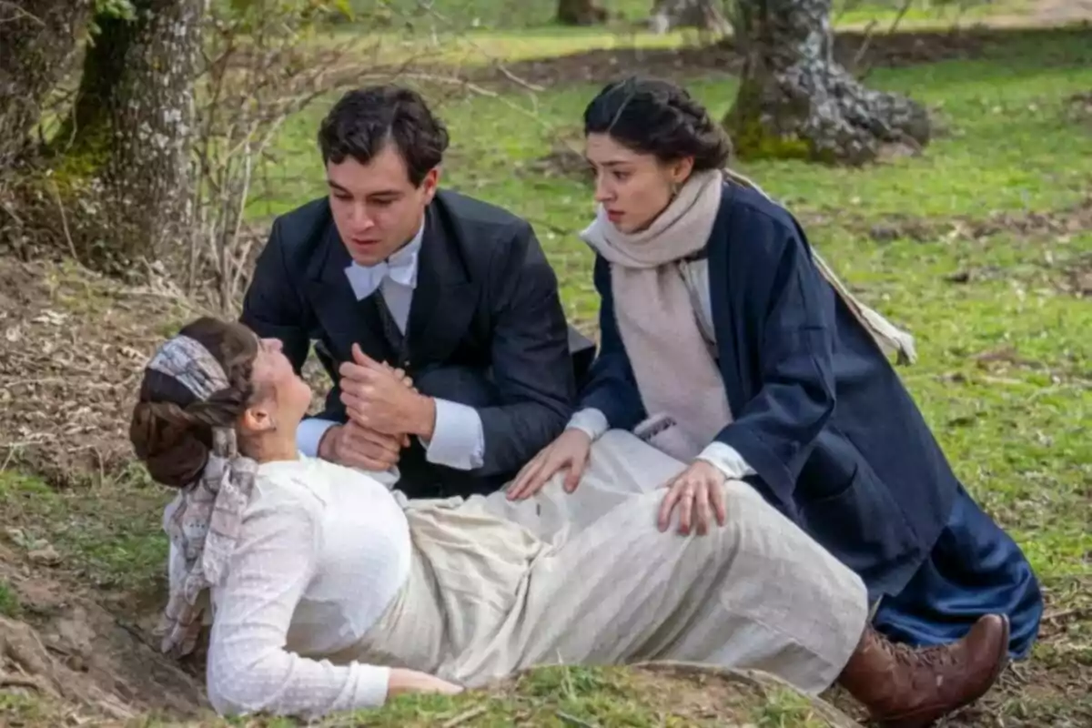 Un hombre y dos mujeres están en un entorno natural, una de las mujeres está recostada en el suelo mientras el hombre y la otra mujer la asisten con preocupación. Captura de 'La Promesa' Un hombre y dos mujeres están en un entorno natural, una de las mujeres está recostada en el suelo mientras el hombre y la otra mujer la asisten con preocupación. Captura de 'La Promesa'