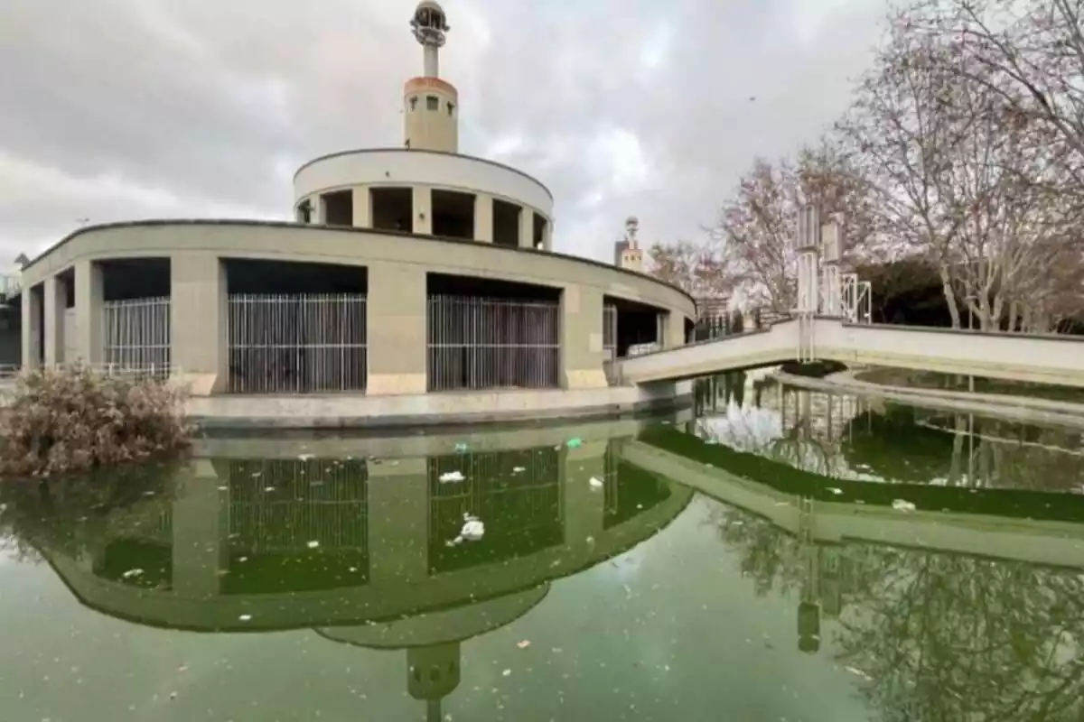 Plano general del lago del Parque de la Espanya Industrial que tiene el agua verde y mucha basura