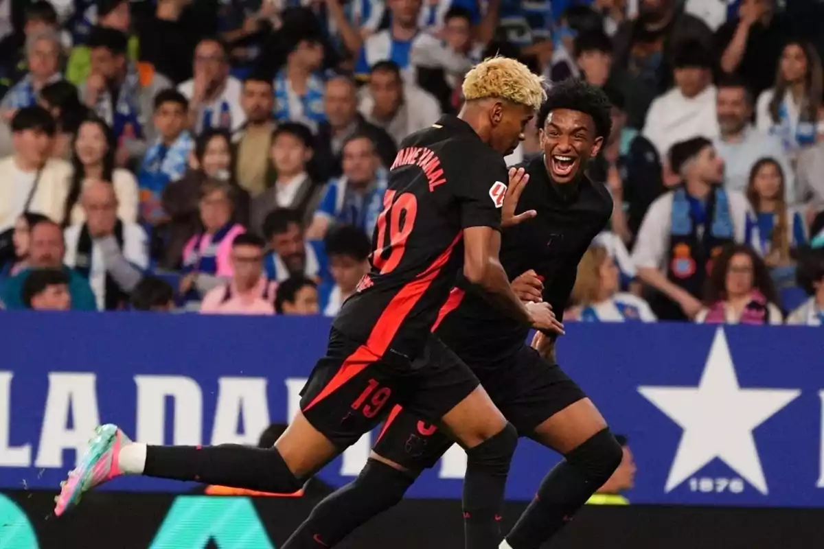Dos jugadores de fútbol celebran un gol en un estadio lleno de aficionados. Dos jugadores de fútbol celebran un gol en un estadio lleno de aficionados.