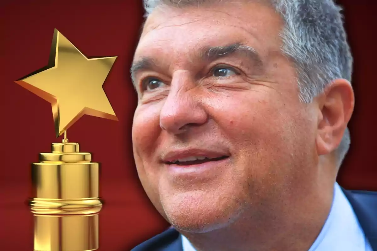 Un hombre sonriente con cabello canoso y ojos claros, con un trofeo dorado en forma de estrella a su lado, sobre un fondo rojo.