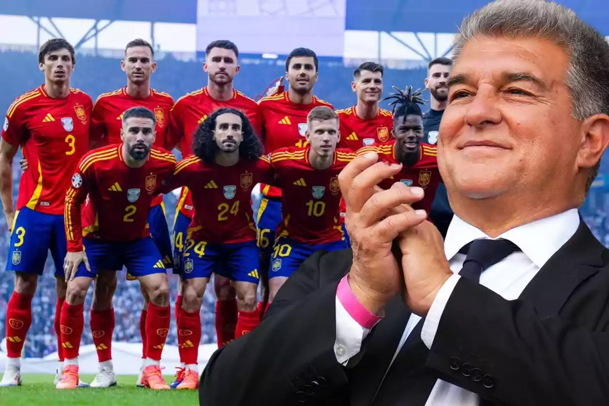 Un equipo de fútbol con uniformes rojos posando para una foto grupal mientras un hombre aplaude en primer plano.