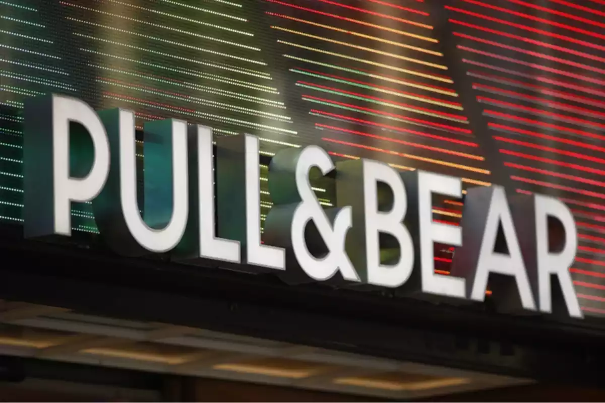 Letrero de la marca de ropa Pull&Bear con luces de colores de fondo en el exterior de una de sus tiendas