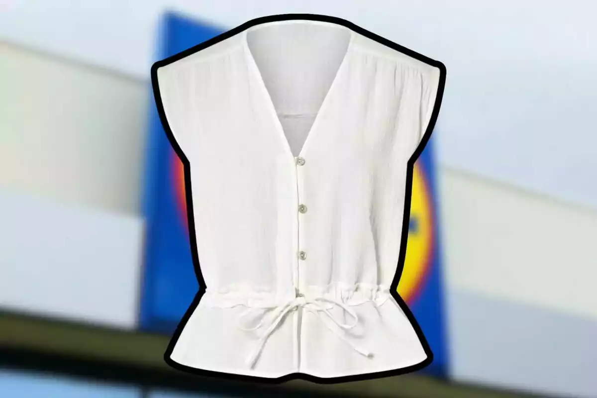 Blusa blanca sin mangas con botones y lazo en la cintura sobre un fondo desenfocado de una tienda Blusa blanca sin mangas con botones y lazo en la cintura sobre un fondo desenfocado de una tienda