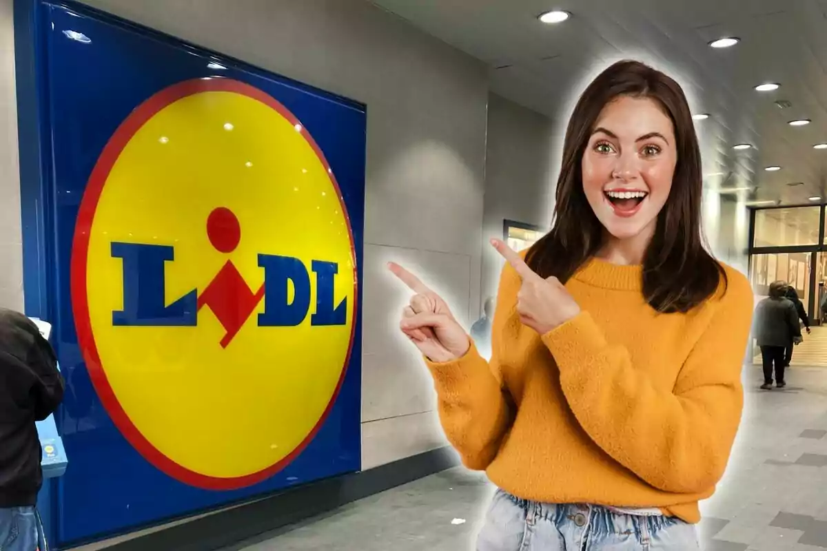 Una mujer sonriente con un suéter amarillo señala el logotipo de Lidl en la entrada de una tienda.