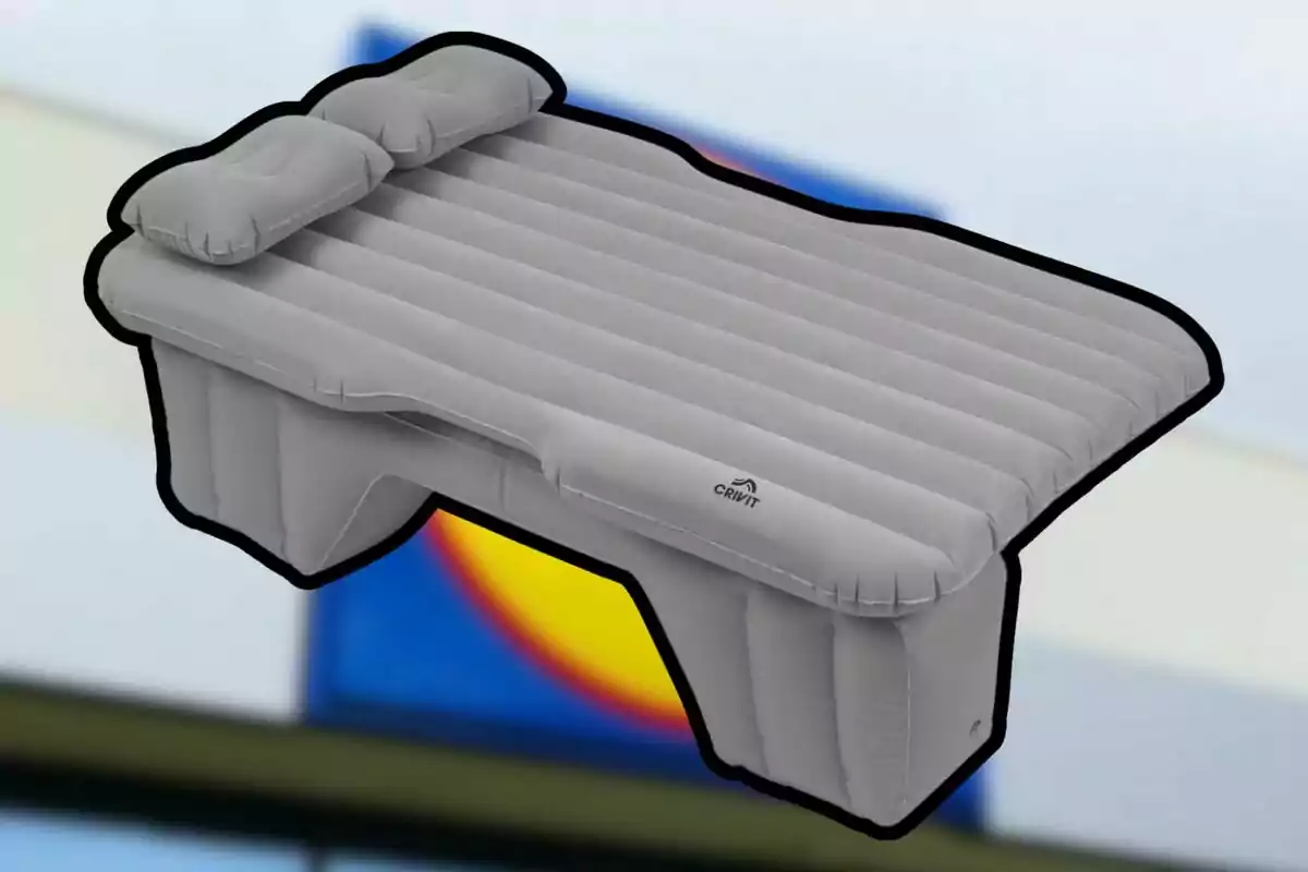 Una cama inflable gris con dos almohadas integradas y soporte en la parte inferior. Una cama inflable gris con dos almohadas integradas y soporte en la parte inferior.