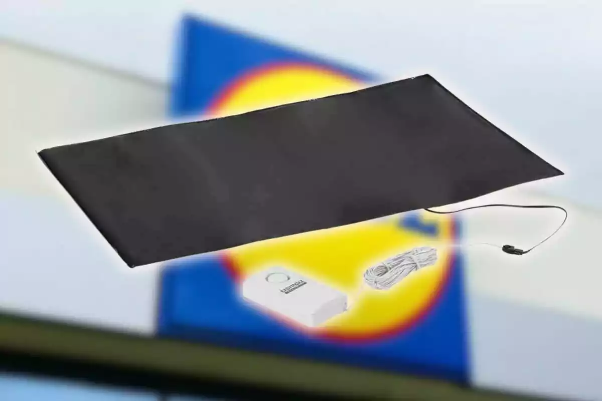 Alfombra térmica negra con control de temperatura y cable de alimentación, con un fondo desenfocado de colores azul y amarillo. Alfombra térmica negra con control de temperatura y cable de alimentación, con un fondo desenfocado de colores azul y amarillo.
