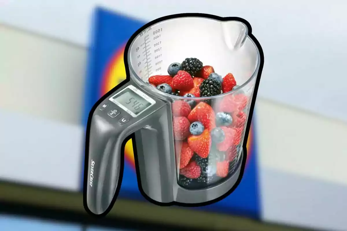 Jarra medidora digital con frutas del bosque en su interior y fondo desenfocado de un supermercado Jarra medidora digital con frutas del bosque en su interior y fondo desenfocado de un supermercado