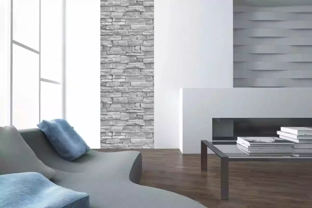 Sala moderna con sofá gris y cojines azules, pared de piedra decorativa y mesa de centro de vidrio sobre piso de madera. Sala moderna con sofá gris y cojines azules, pared de piedra decorativa y mesa de centro de vidrio sobre piso de madera.