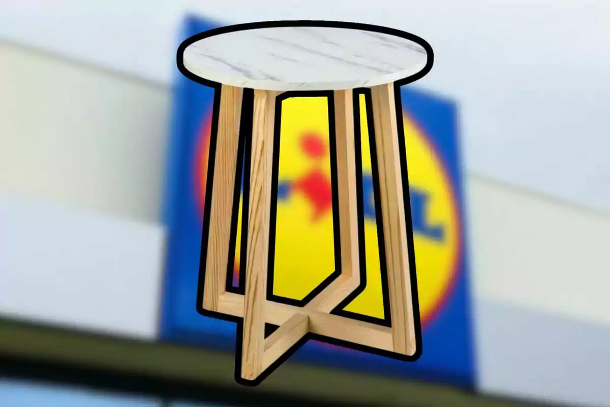 Una mesa redonda con patas de madera y un tablero de mármol frente a un fondo borroso de un logotipo. Una mesa redonda con patas de madera y un tablero de mármol frente a un fondo borroso de un logotipo.
