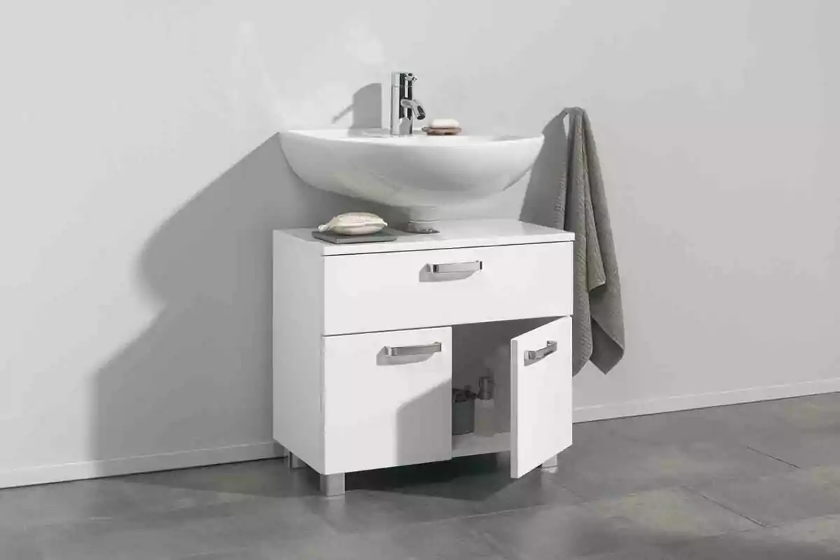 Un mueble de baño blanco con lavabo integrado y toalla colgada al lado. Un mueble de baño blanco con lavabo integrado y toalla colgada al lado.