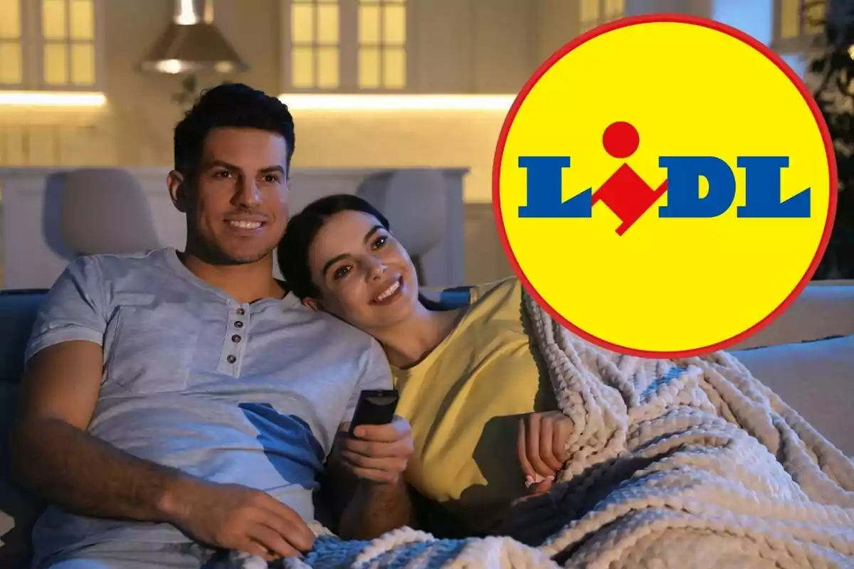 Una pareja sonriente sentada en un sofá viendo televisión con el logo de Lidl superpuesto en la esquina.