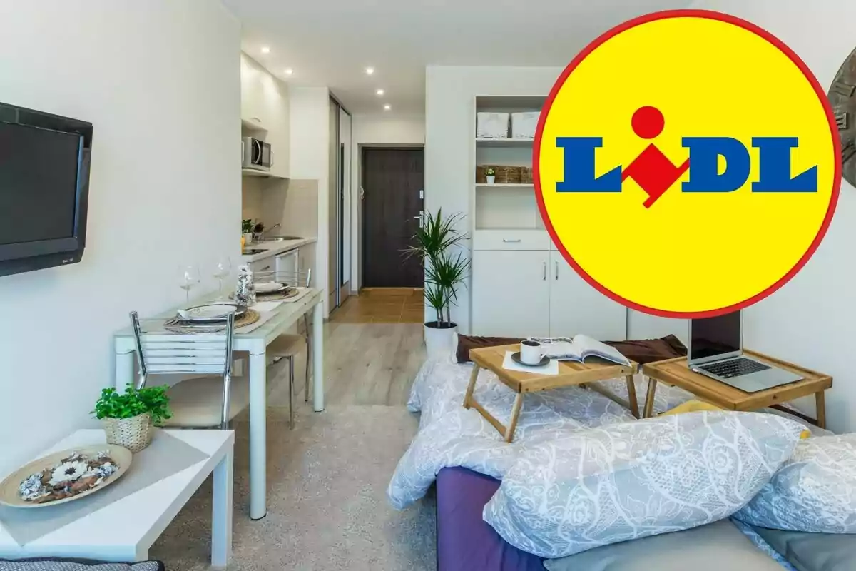 Una habitación moderna y bien iluminada con una pequeña cocina, una mesa de comedor y una cama con bandejas de desayuno, con el logotipo de Lidl superpuesto en la esquina derecha.