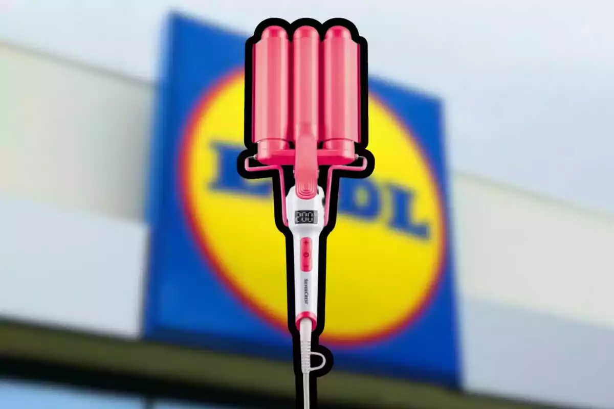 Rizador de cabello rosa con pantalla digital en primer plano frente a un letrero borroso de la tienda Lidl Rizador de cabello rosa con pantalla digital en primer plano frente a un letrero borroso de la tienda Lidl