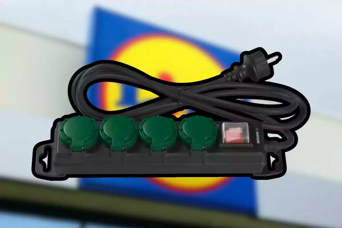 Una regleta de enchufes con interruptor y cuatro tomas verdes frente a un fondo desenfocado con colores azul y amarillo. Una regleta de enchufes con interruptor y cuatro tomas verdes frente a un fondo desenfocado con colores azul y amarillo.