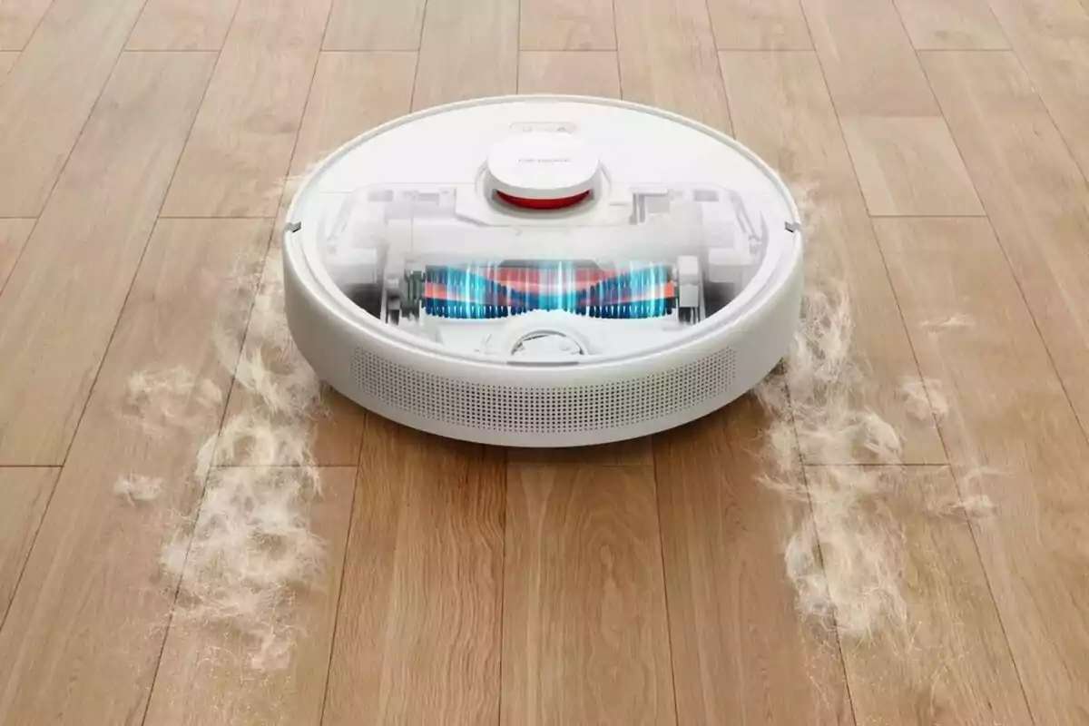 Un robot aspirador limpiando un suelo de madera con polvo y pelos alrededor. Un robot aspirador limpiando un suelo de madera con polvo y pelos alrededor.