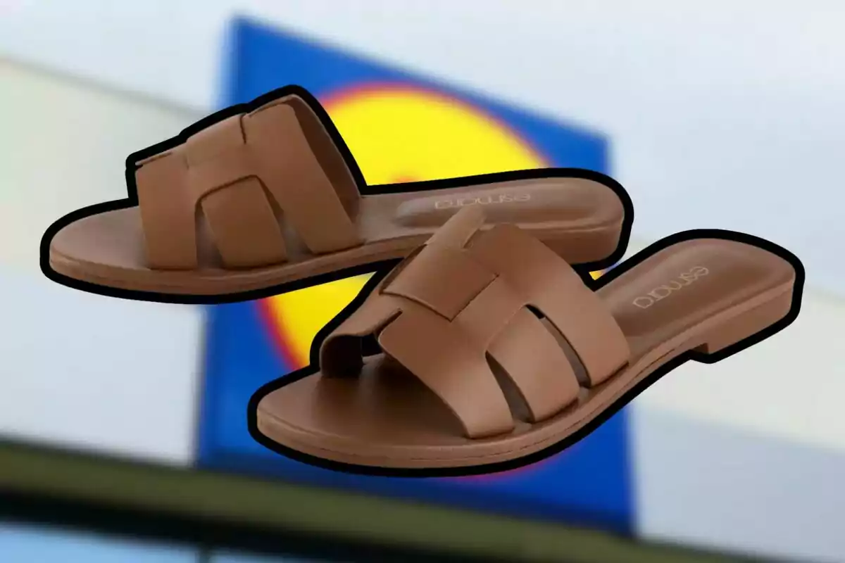 Un par de sandalias marrones con diseño entrelazado sobre un fondo desenfocado de colores azul y amarillo. Un par de sandalias marrones con diseño entrelazado sobre un fondo desenfocado de colores azul y amarillo.