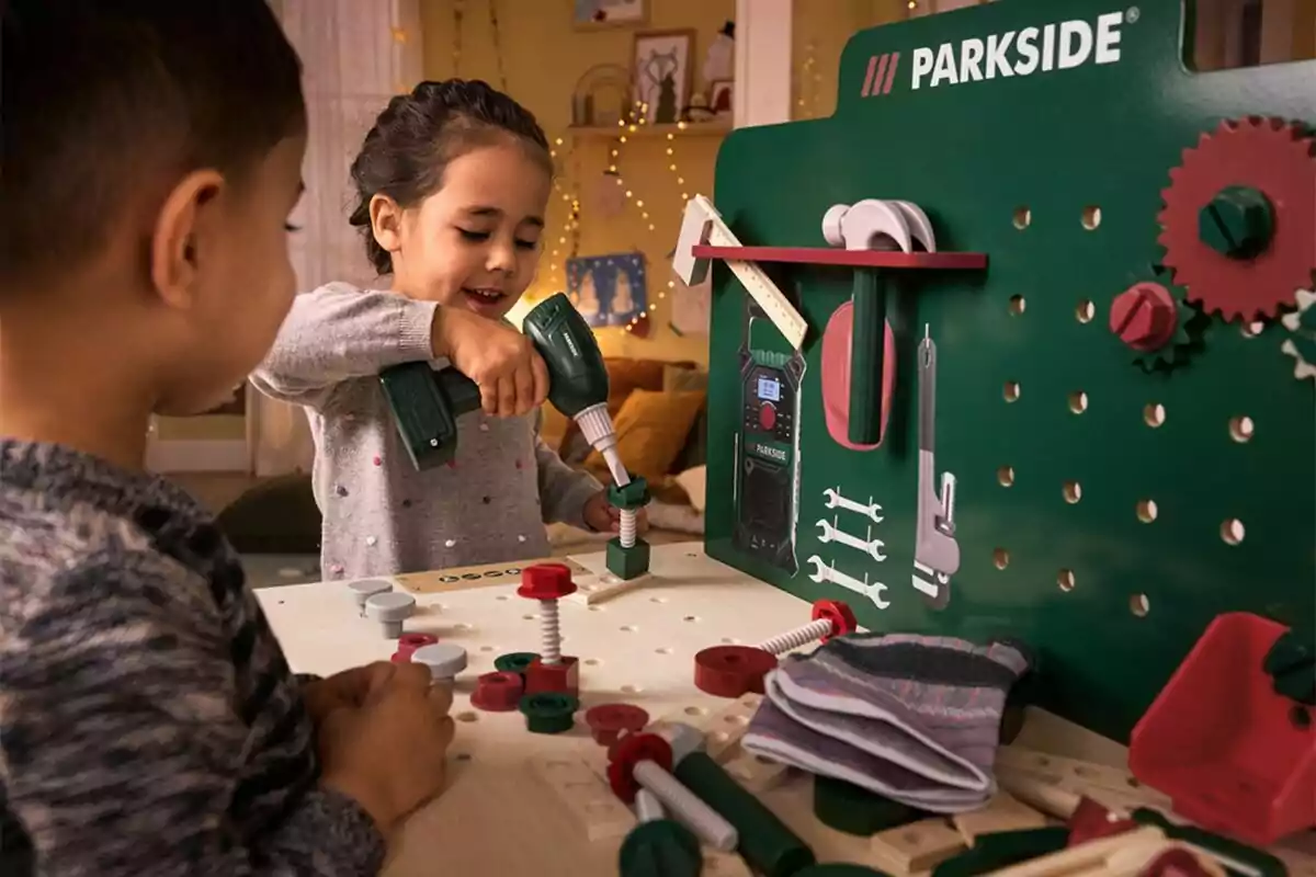 Niños jugando con un banco de herramientas de juguete en una habitación iluminada. Niños jugando con un banco de herramientas de juguete en una habitación iluminada.