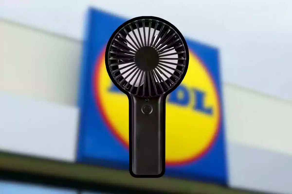 Un ventilador portátil negro frente a un cartel de una tienda. Un ventilador portátil negro frente a un cartel de una tienda.