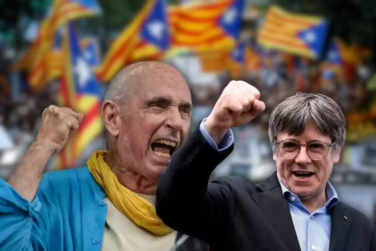 Dos personas levantando el puño en señal de protesta con banderas catalanas ondeando en el fondo.