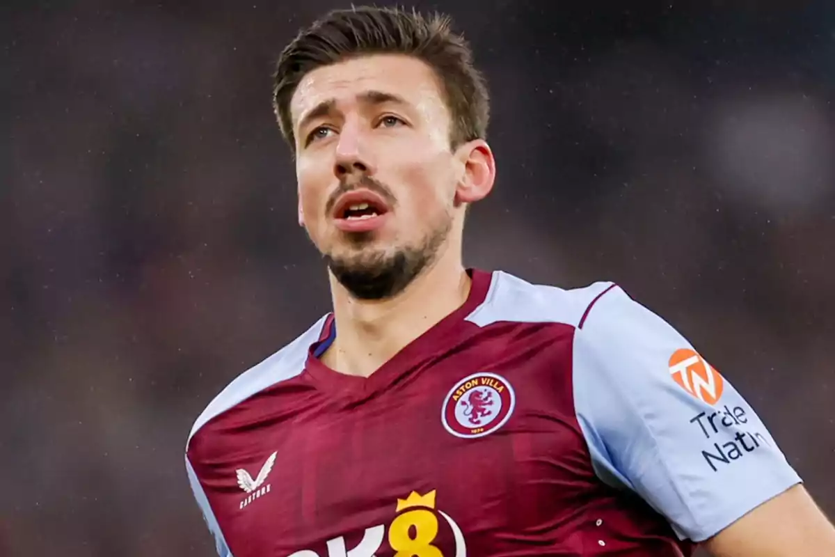 Jugador de fútbol con camiseta del Aston Villa en el campo de juego.