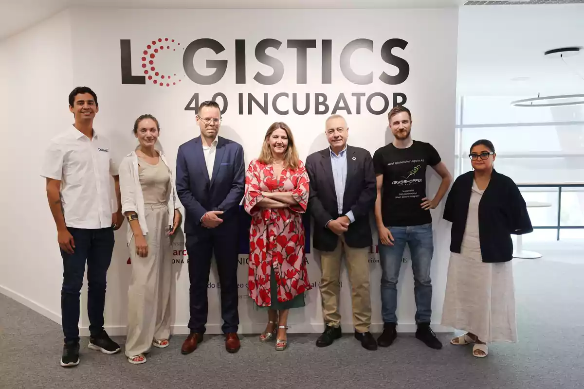 Un grupo de personas posando frente a una pared con el texto "LOGISTICS 4.0 INCUBATOR".