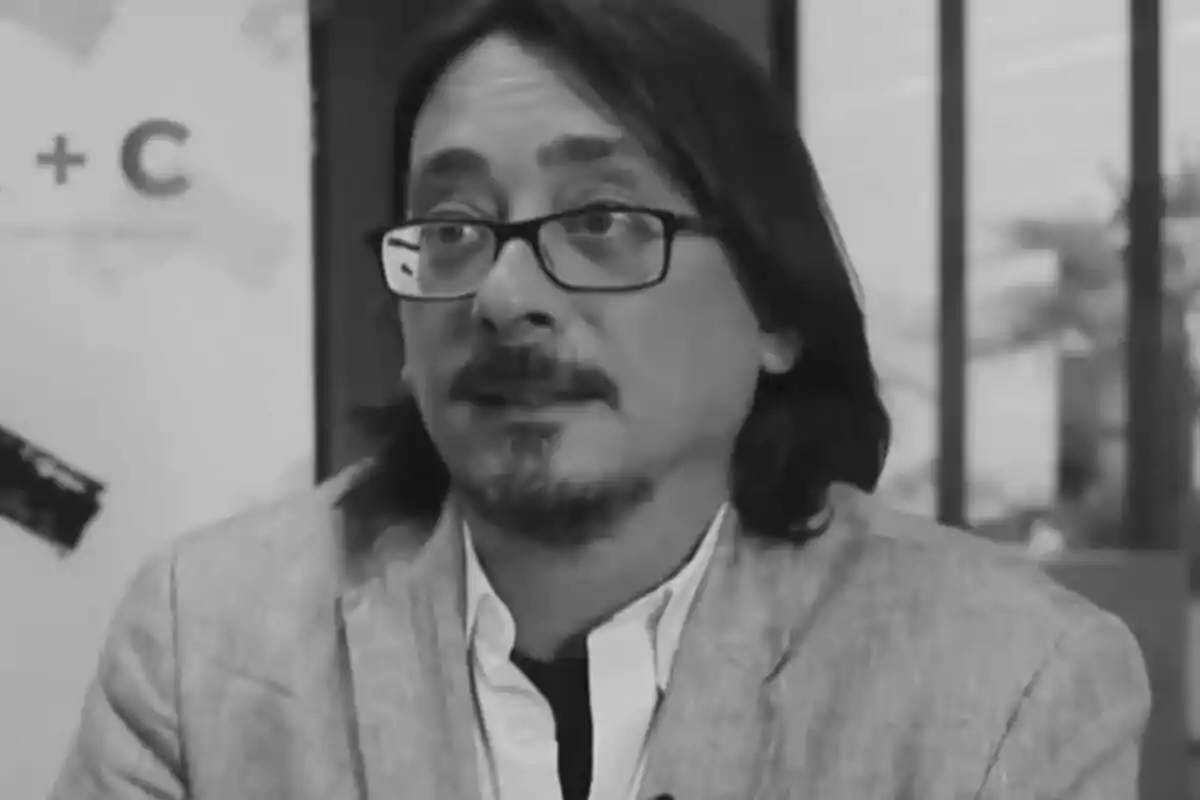 Luis Felipe Torrente con gafas y barba, vestido con saco claro y camisa blanca, en una imagen en blanco y negro.