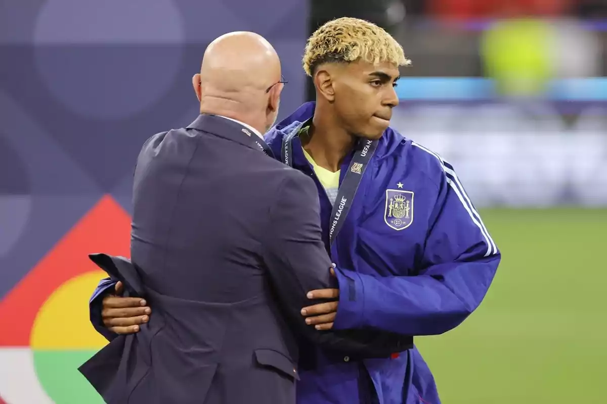 Jugador de la selección española de fútbol recibiendo una medalla y siendo felicitado por un hombre calvo con gafas en un evento deportivo Jugador de la selección española de fútbol recibiendo una medalla y siendo felicitado por un hombre calvo con gafas en un evento deportivo