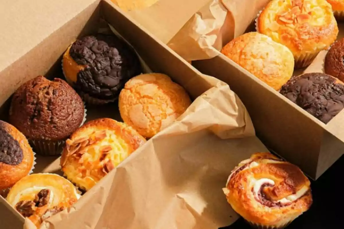 Caja de cartón con diferentes tipos de panecillos y muffins variados Caja de cartón con diferentes tipos de panecillos y muffins variados