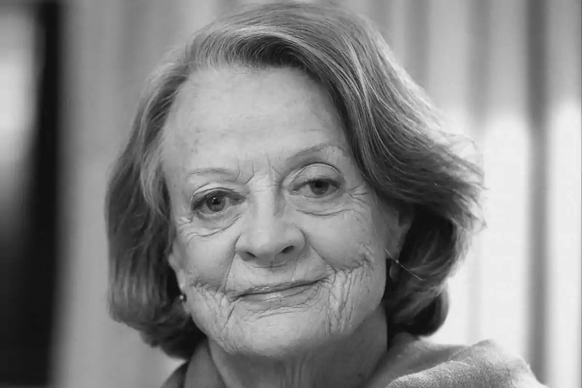 Fotografía en blanco y negro de Maggie Smith con expresión serena y cabello corto.