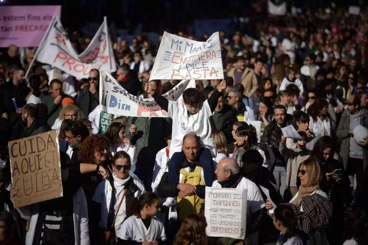 Plano general de la manifestación de enfermeras en Barcelona, con decenas de personas con pancartas reincidicativas