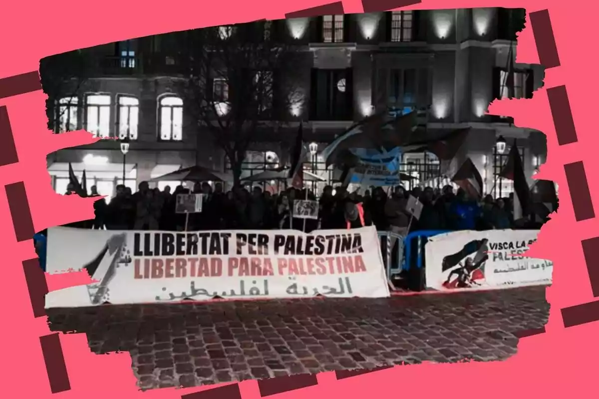 Una manifestación nocturna en la calle con pancartas que expresan apoyo a Palestina, rodeada de un marco rojo.