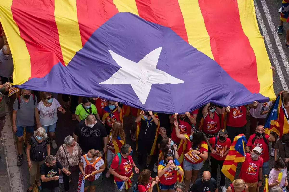 Varias personas portan una bandera estelada durante la manifestación organizada por la Asamblea Nacional Catalana (ANC) con motivo de la Diada, día de Cataluña, a 11 de septiembre de 2021, en Barcelona