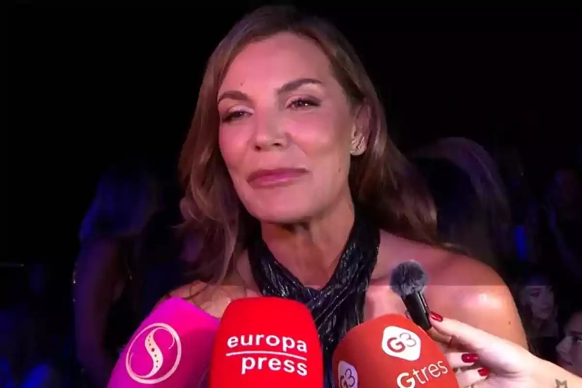 Mar Flores siendo entrevistada por varios medios de comunicación con micrófonos de diferentes colores. Mar Flores siendo entrevistada por varios medios de comunicación con micrófonos de diferentes colores.