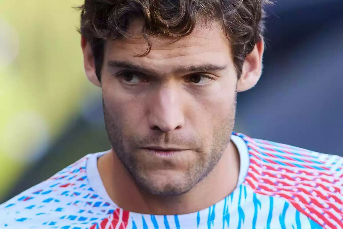 Marcos Alonso mirando a un costado con cara de preocupación y la camiseta de calentamiento del Barça