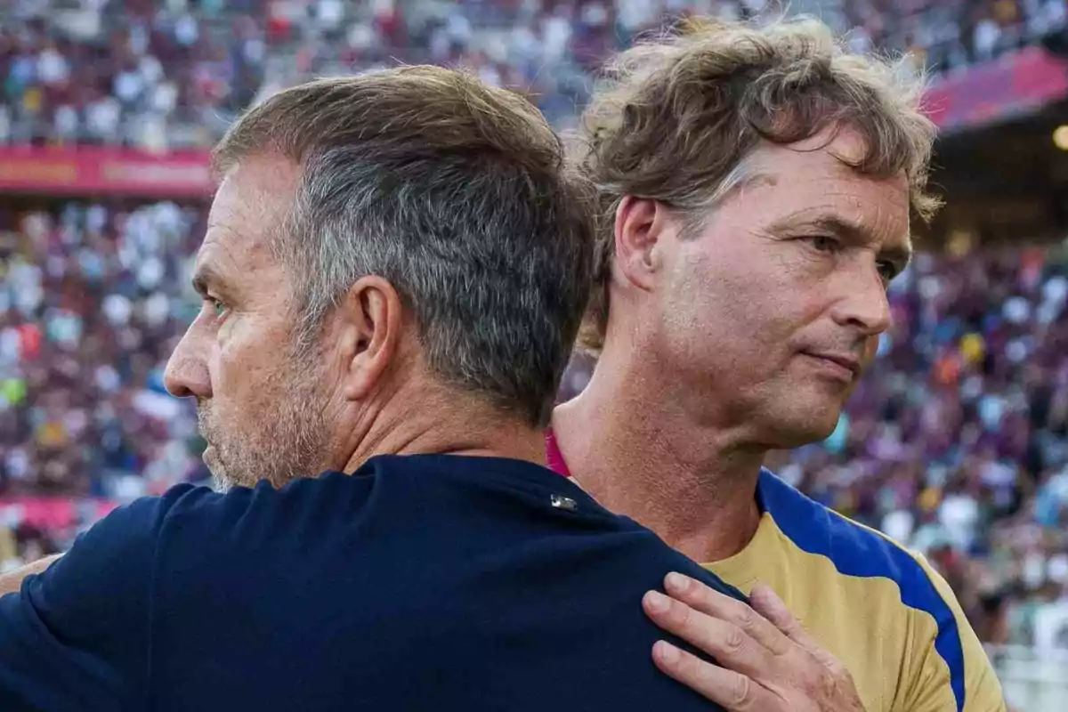 Dos hombres se abrazan en un estadio lleno de gente. Dos hombres se abrazan en un estadio lleno de gente.