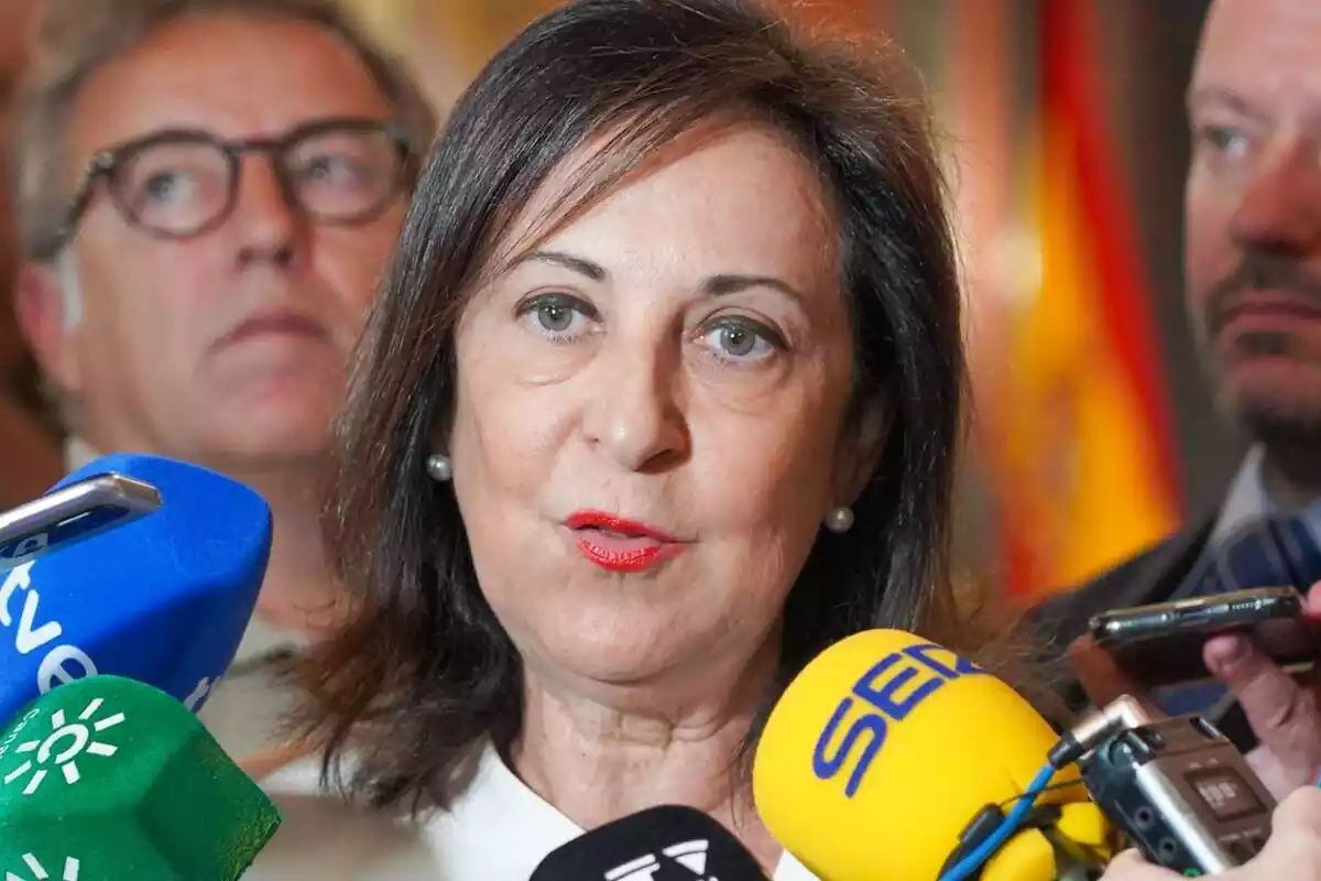 Primer plano de Margarita Robles con los labios pintados de rojo hablando ante varios micrófonos de medios de comunicación Primer plano de Margarita Robles con los labios pintados de rojo hablando ante varios micrófonos de medios de comunicación