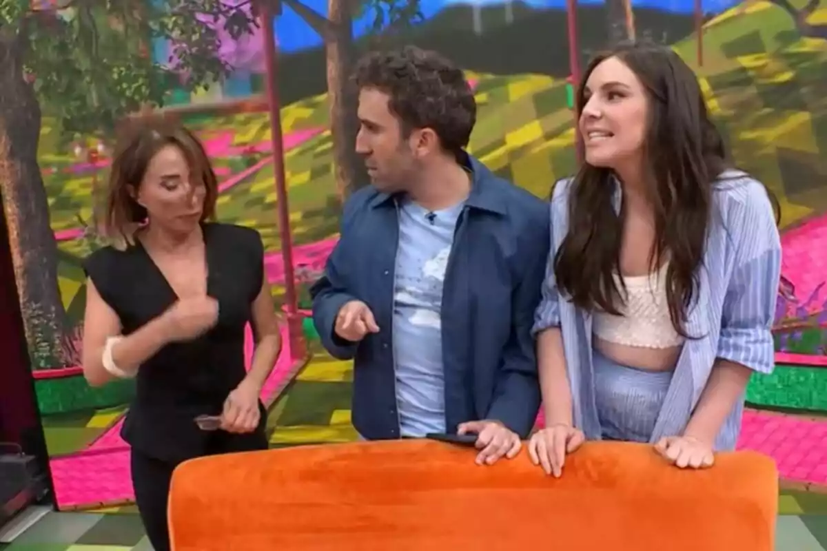 María Patiño, Aitor Albizia e Inés Hernand conversan animadamente en un set colorido con un fondo de árboles y patrones geométricos de La Familia de la Tele. María Patiño, Aitor Albizia e Inés Hernand conversan animadamente en un set colorido con un fondo de árboles y patrones geométricos de La Familia de la Tele.