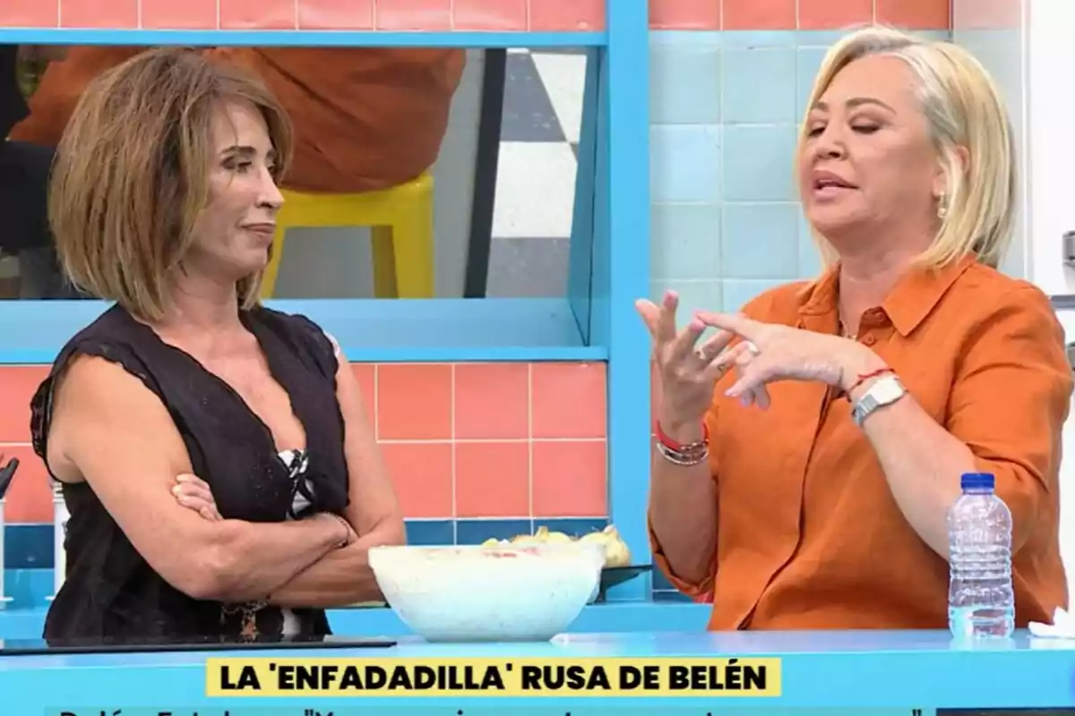 María Patiño y Belén Esteban conversan en una cocina en La Familia de la Tele, una de ellas con los brazos cruzados y la otra gesticulando, con un recipiente de ensalada sobre la mesa. María Patiño y Belén Esteban conversan en una cocina en La Familia de la Tele, una de ellas con los brazos cruzados y la otra gesticulando, con un recipiente de ensalada sobre la mesa.