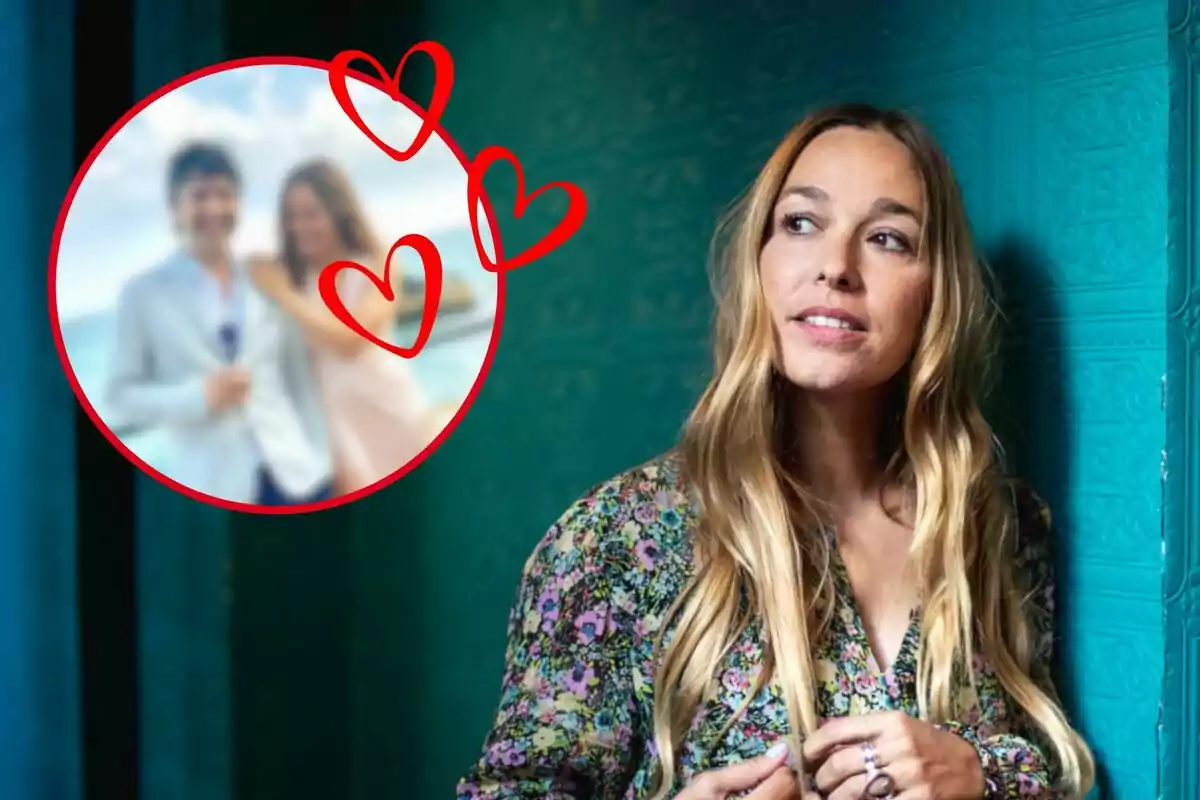 Una mujer con cabello largo y rubio, vestida con una blusa de flores, está de pie junto a una pared verde, mientras que en un círculo rojo con corazones hay una imagen borrosa de una pareja.