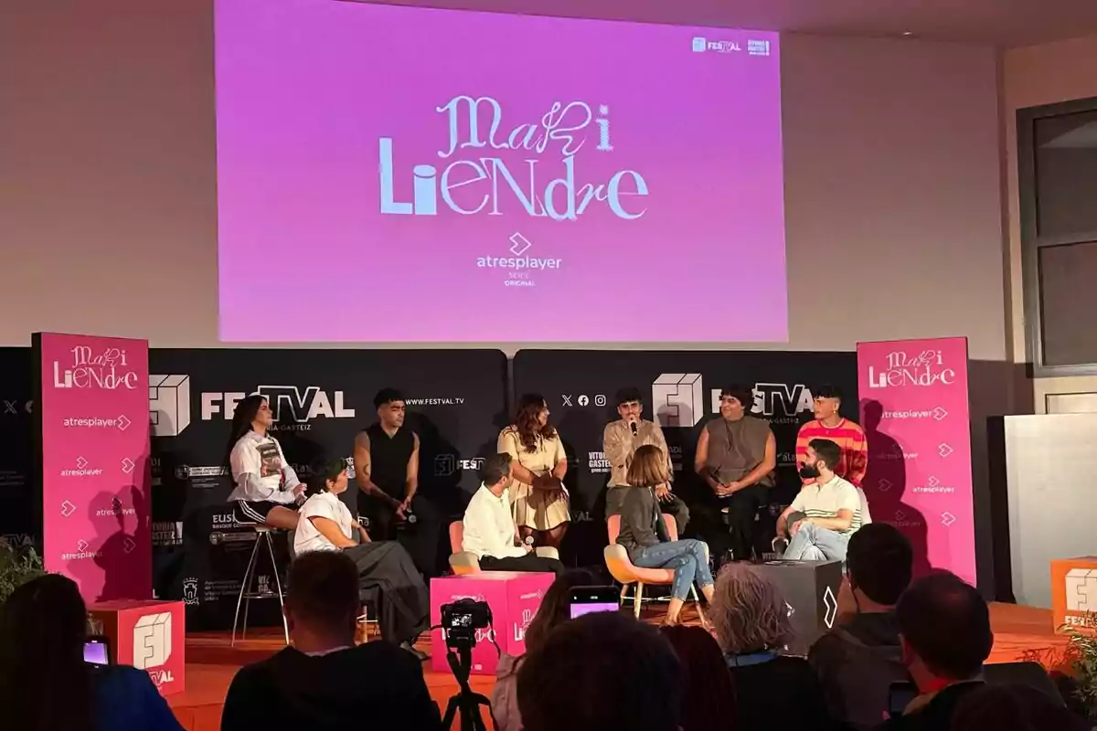 Un grupo de personas como Montse García, Emilio Sánchez Zaballos, Martin Urrutia, Omar Ayuso, Blanca Martínez, Yenesi o Carlos González está sentado en un escenario participando en un panel de discusión, con un cartel rosa de "Mariliendre" y "atresplayer" en el fondo.