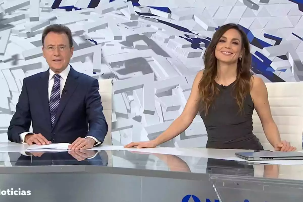 Captura de Matías Prats y Mónica Carrillo como presentadores de Antena 3 Noticias con un fondo geométrico blanco y azul.